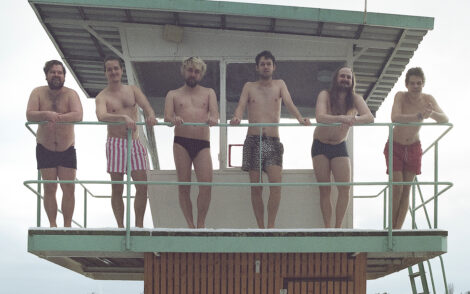 Die fünf Mitglieder der Band B6BBO stehen in Badehosen auf dem Rettungsturm des Strandbades Berlin-Wendenschloss