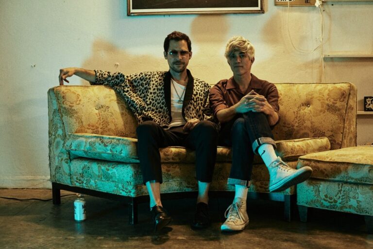 Chris Cain und Keith Murray der Band "We Are Scientists" sitzen auf einem Sofa in Vintage-Optik