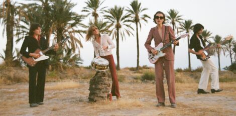 Die Band spielt Musik am Strand unter Palmen.