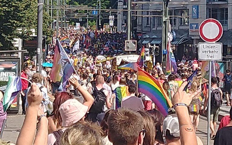 Demonstrierender Menschenzug vom Doberaner Platz zum Schröderplatz in Rostock, hier Christopher Street Day am 17.07.2021. Menschen halten Fahnen mit LGBTQIA*-Bezug